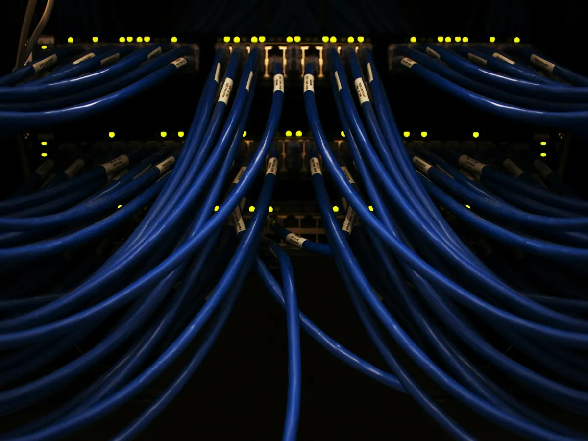 Blue network cables running into a rack of switches